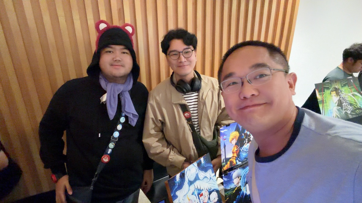 Terry taking a selfie with two illustrators and their colorful prints at a creative market