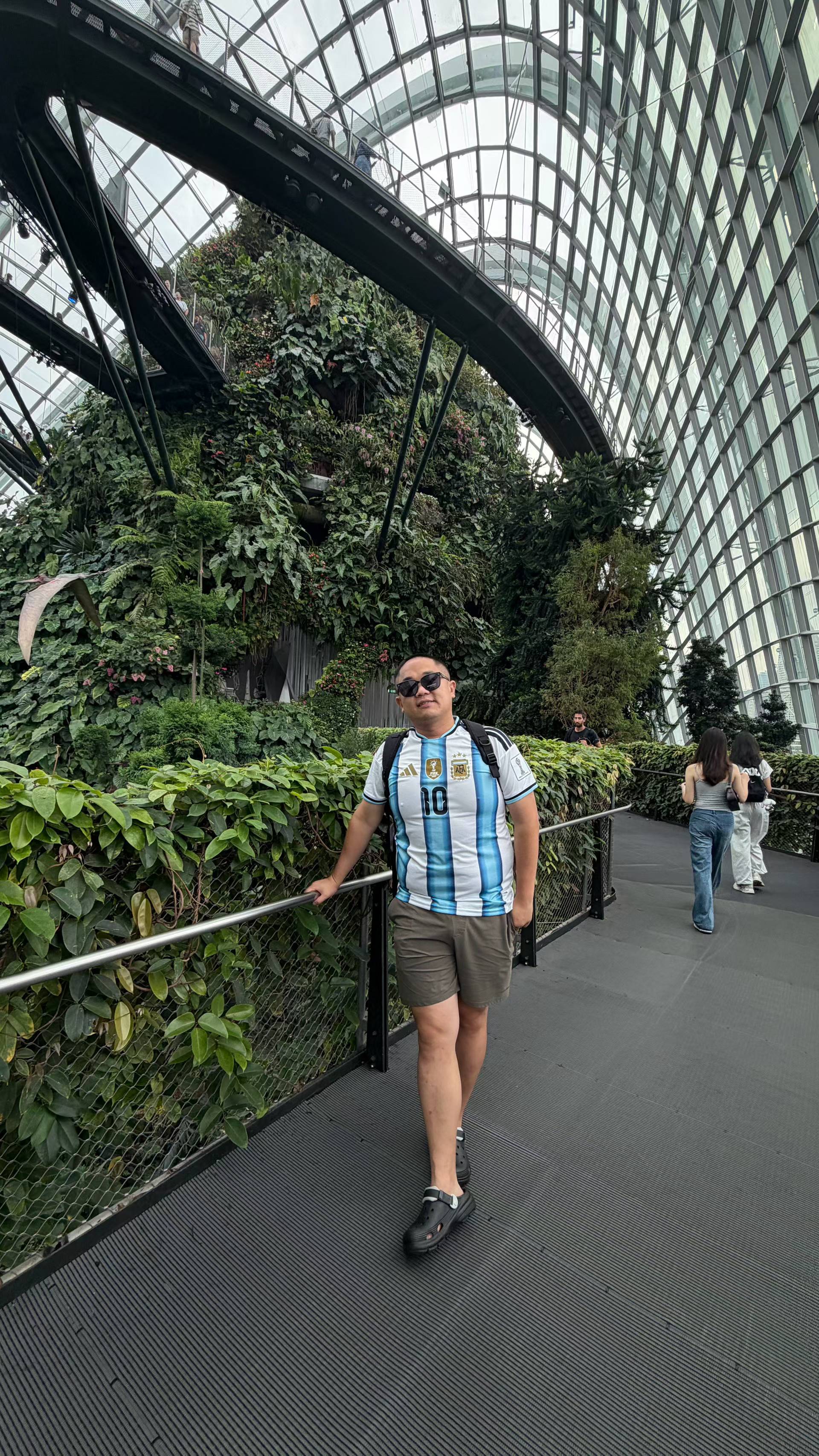 Terry standing beside the lush indoor mountain and elevated walkways inside Cloud Forest