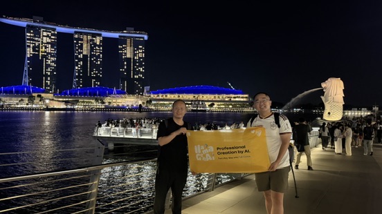 Terry and a friend holding a Professional Creation by AI banner at Merlion Park with Marina Bay Sands behind them